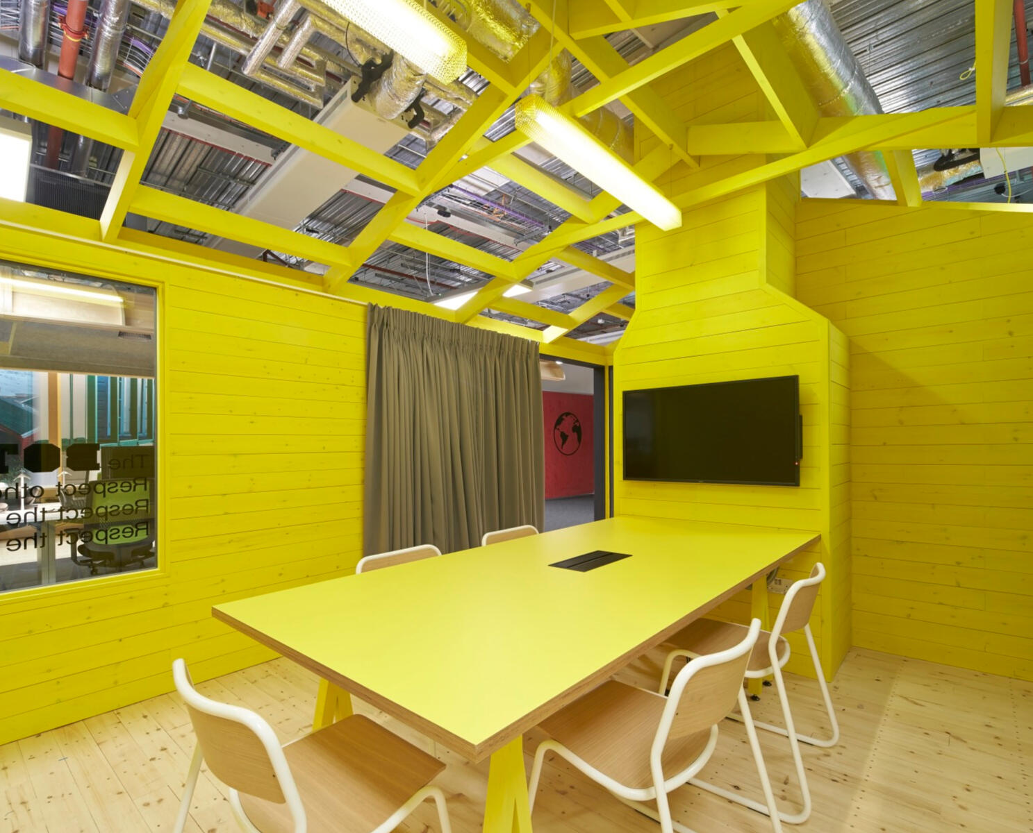 yellow conference room featuring a large table surrounded by several chairs